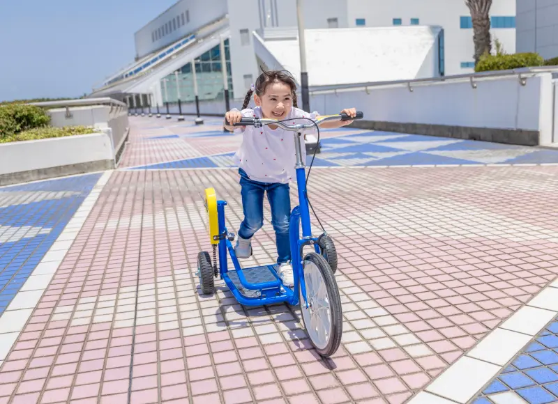 A girl enjoying a unique bicycle outdoors.