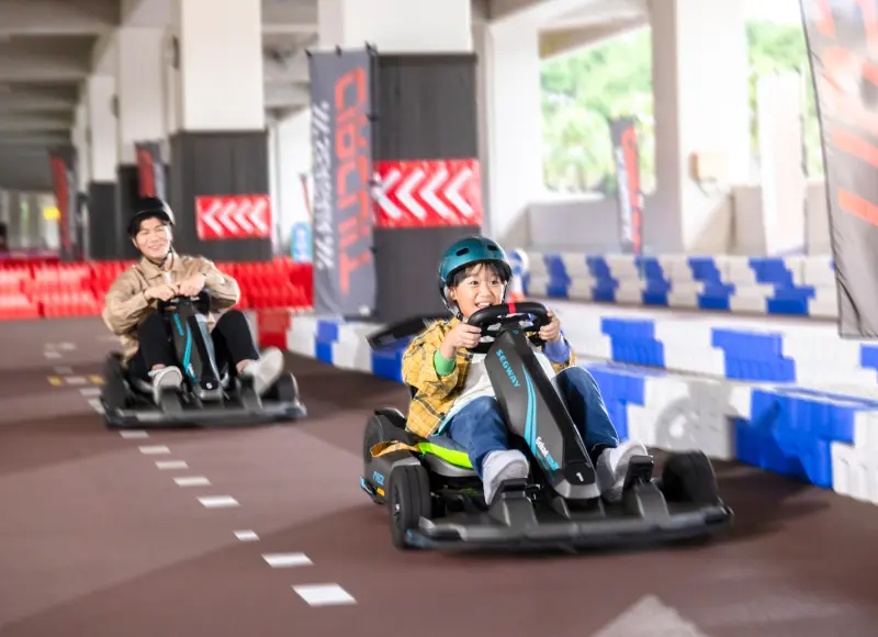A parent and child enjoying electric go-karts at SEAGAIA Circuit