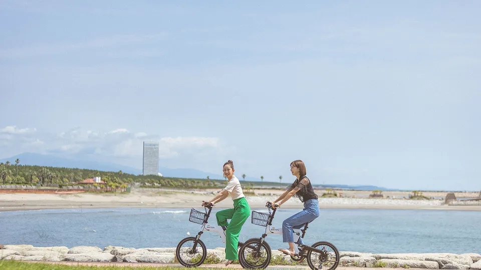 Women riding electric bicycles on the beach