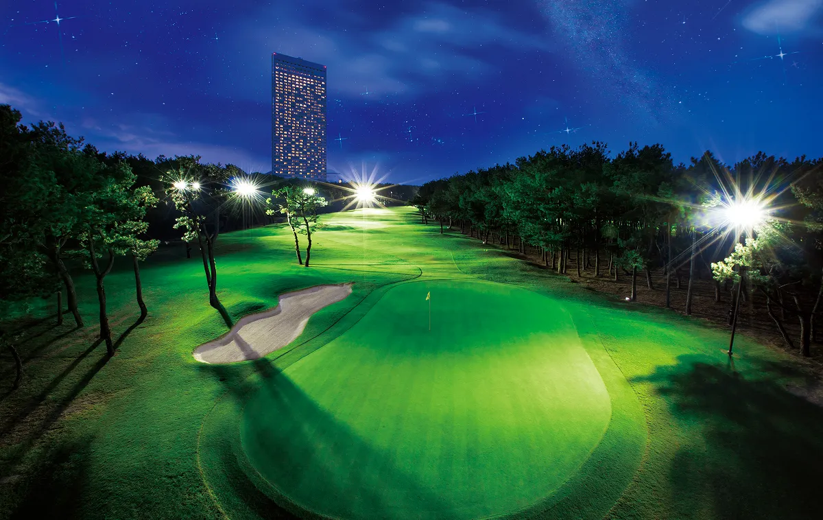 Night view of a golf course illuminated by nighttime lighting.