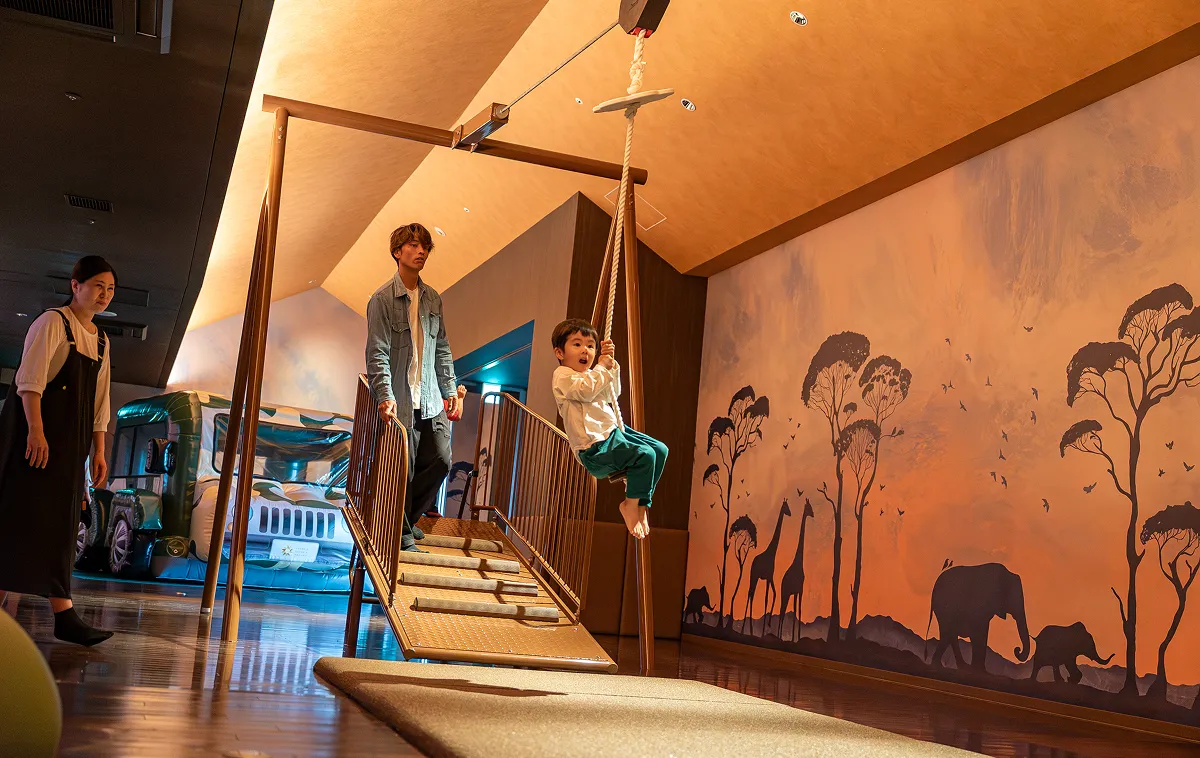 Children playing on the zipline at KIDS OASIS, with their guardians watching over them.
