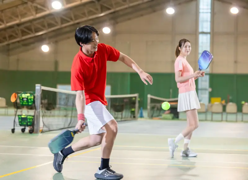 A man hitting a smash on a pickleball court.