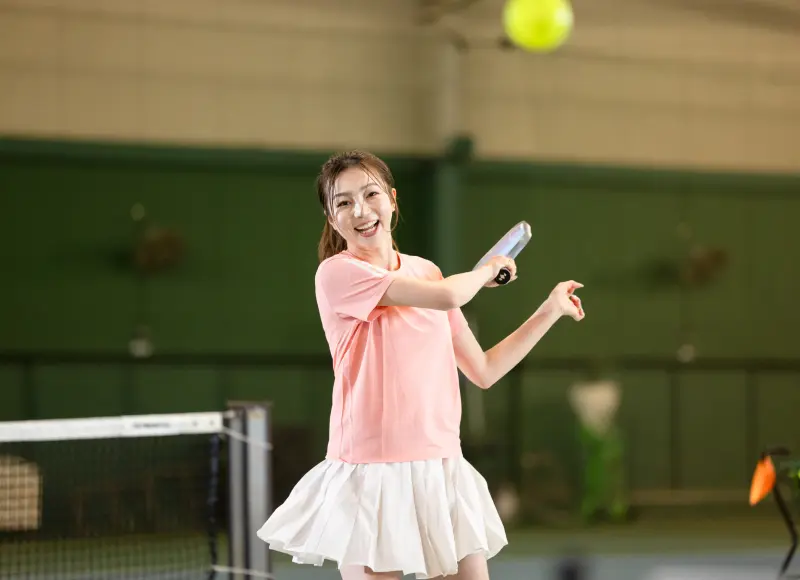 A woman hitting shots on a pickleball court.
