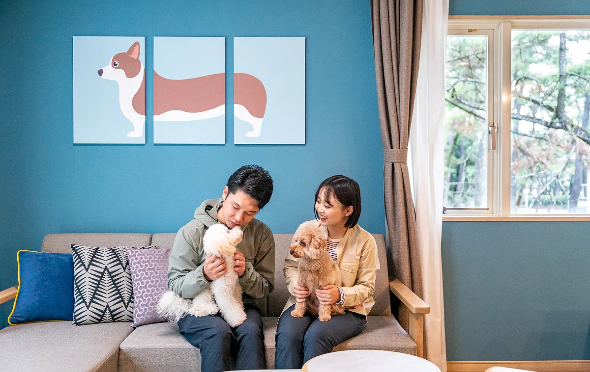 A couple and their dog relaxing in a dog-friendly room.