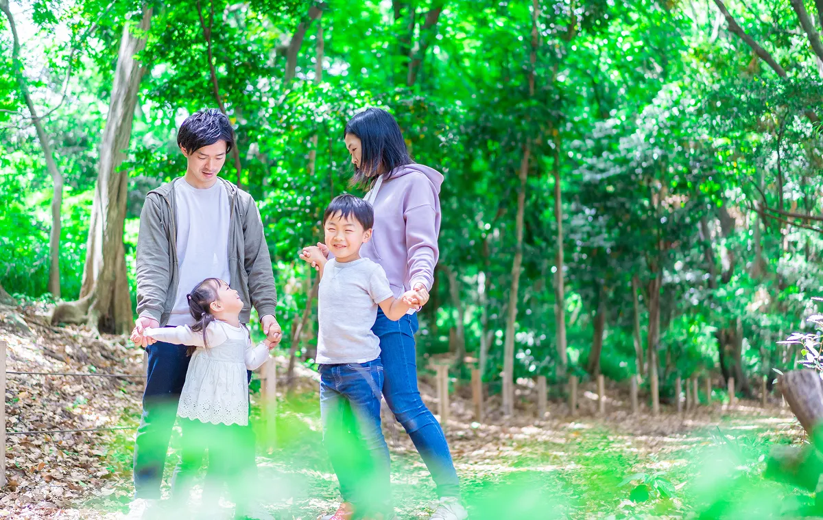 A family walking through a lush green forest